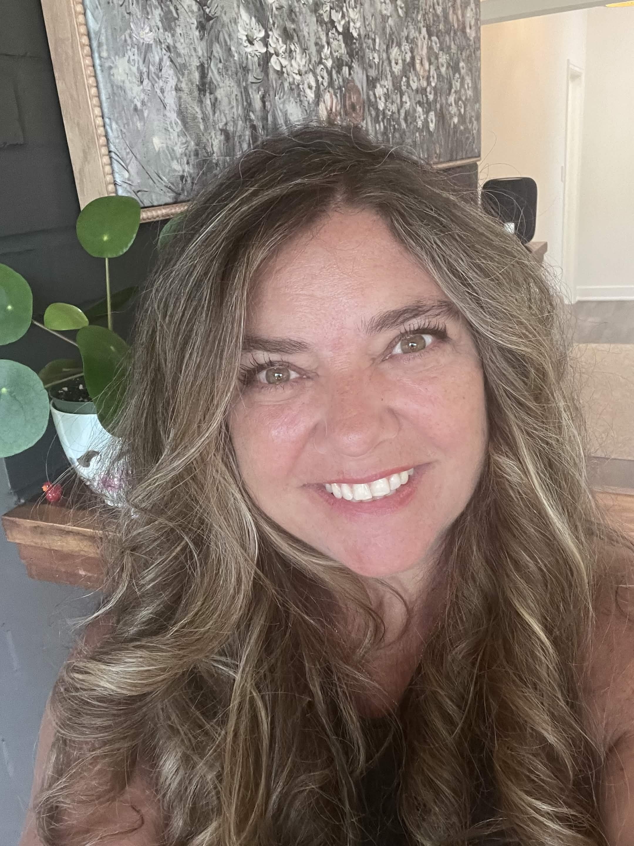 Judy Batten smiling in a softly lit wellness portrait